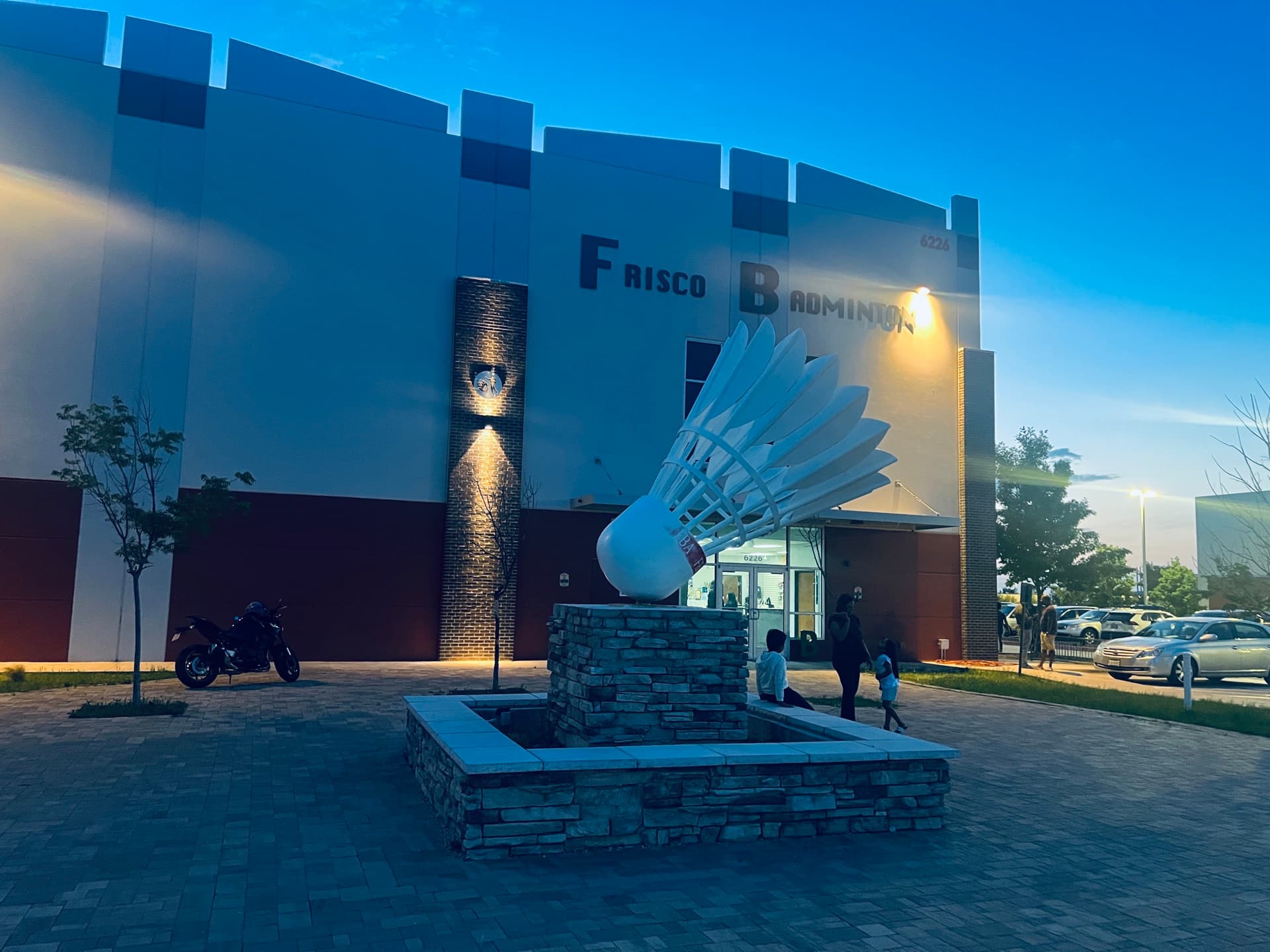 Frisco Badminton Academy building at dusk with the giant shuttlecock sculpture out front