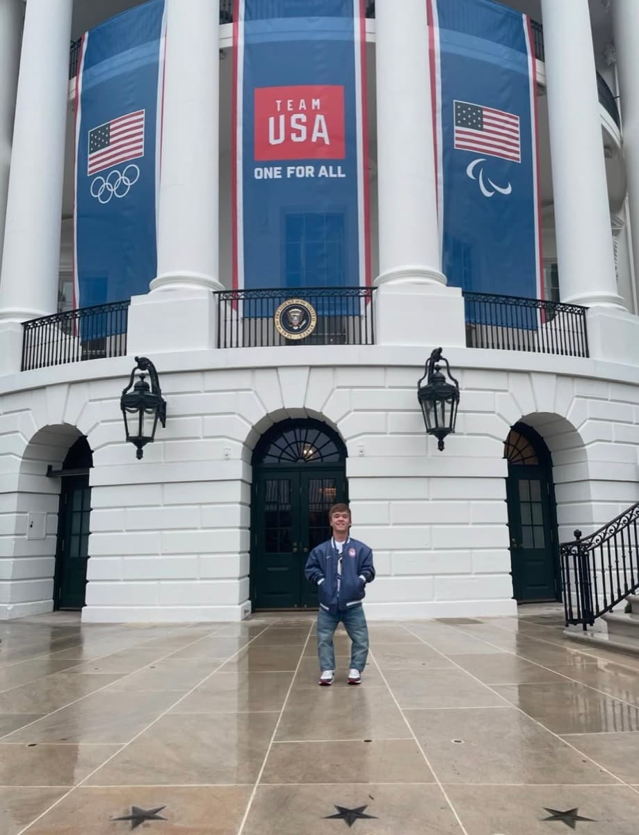 Miles Krajewski standing in front of the White House with Team USA banners