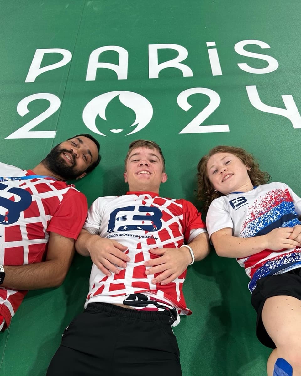 Abhishek, Miles, and Jayci lying on the Paris 2024 court logo